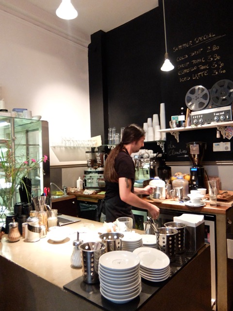 Barista preparing drinks behind the Black Delight coffee counter