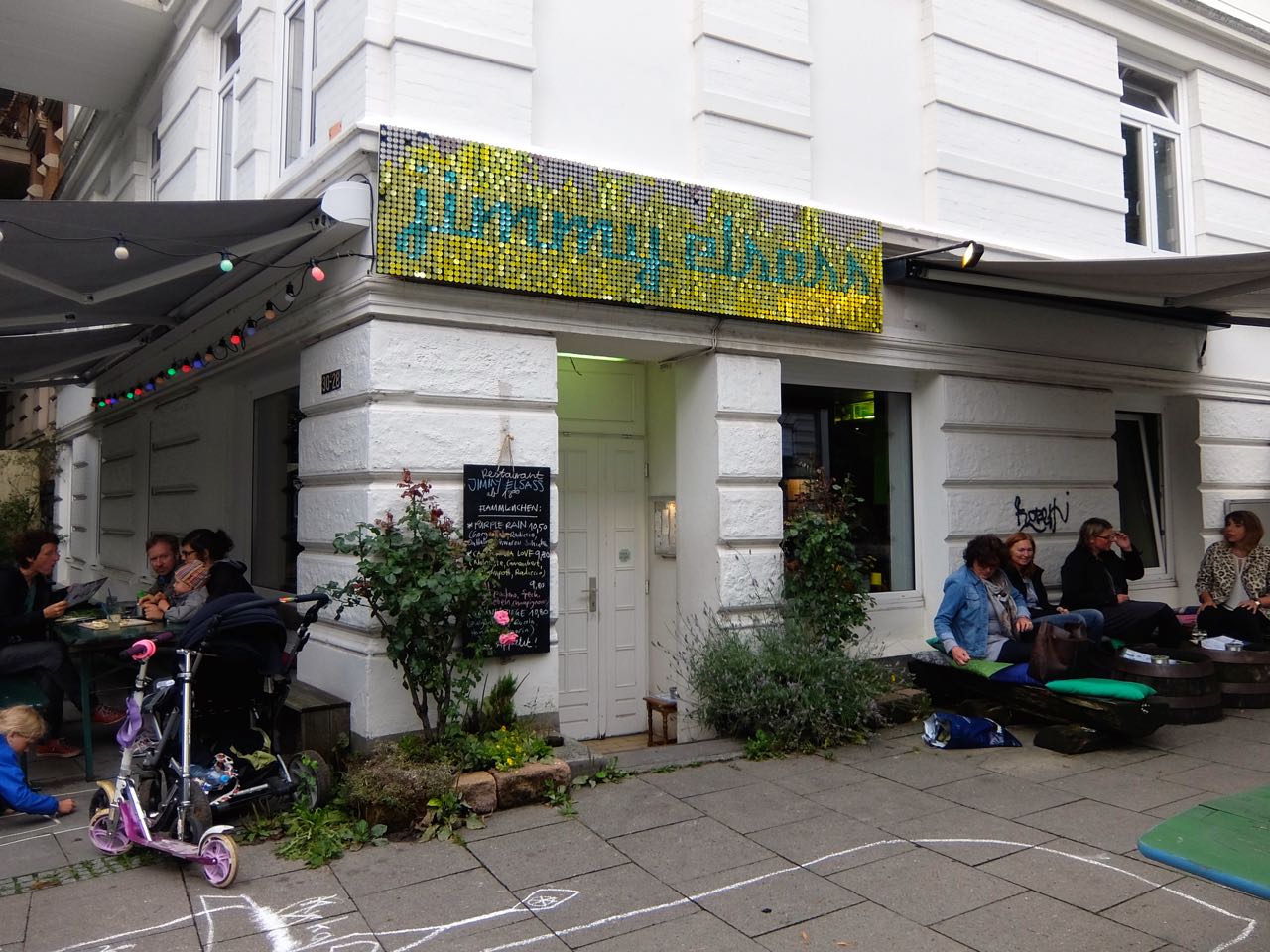 Exterior of Jimmy Elsass restaurant in Hamburg with guests seated outside