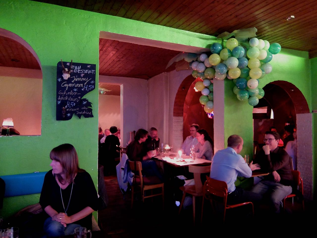 Green dining room and colorful hanging lights inside Jimmy Elsass